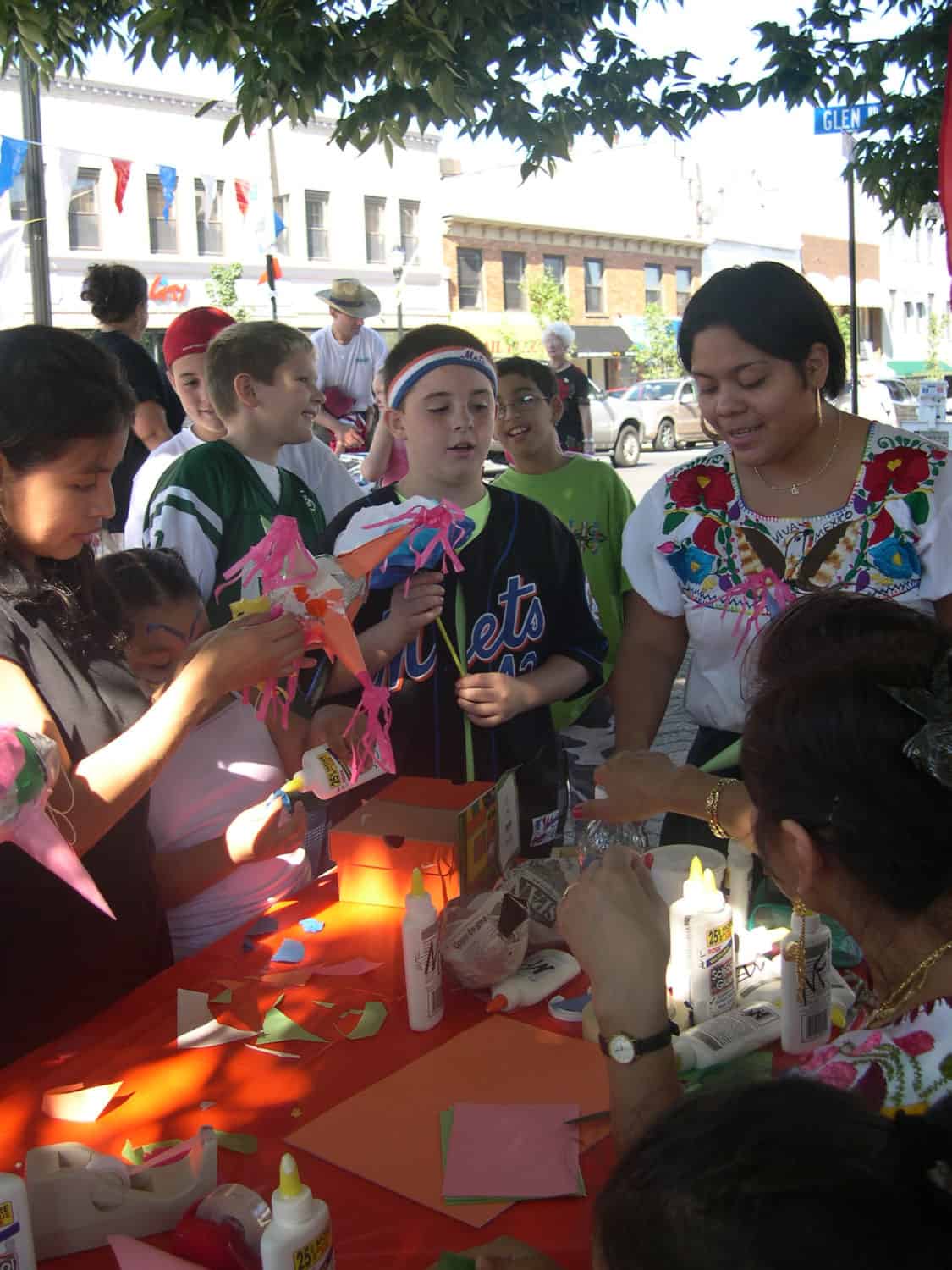 A group of people at a table constructing decorative items with paper
