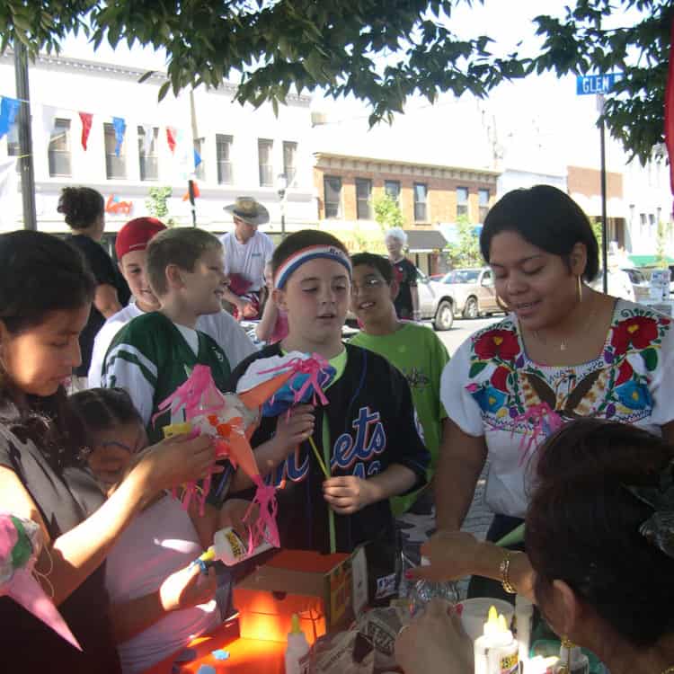 A group of people at a table constructing decorative items with paper