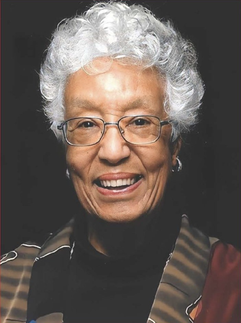 headshot of marilyn white, who has white hair, wears glasses, and has a brown and black striped jacket