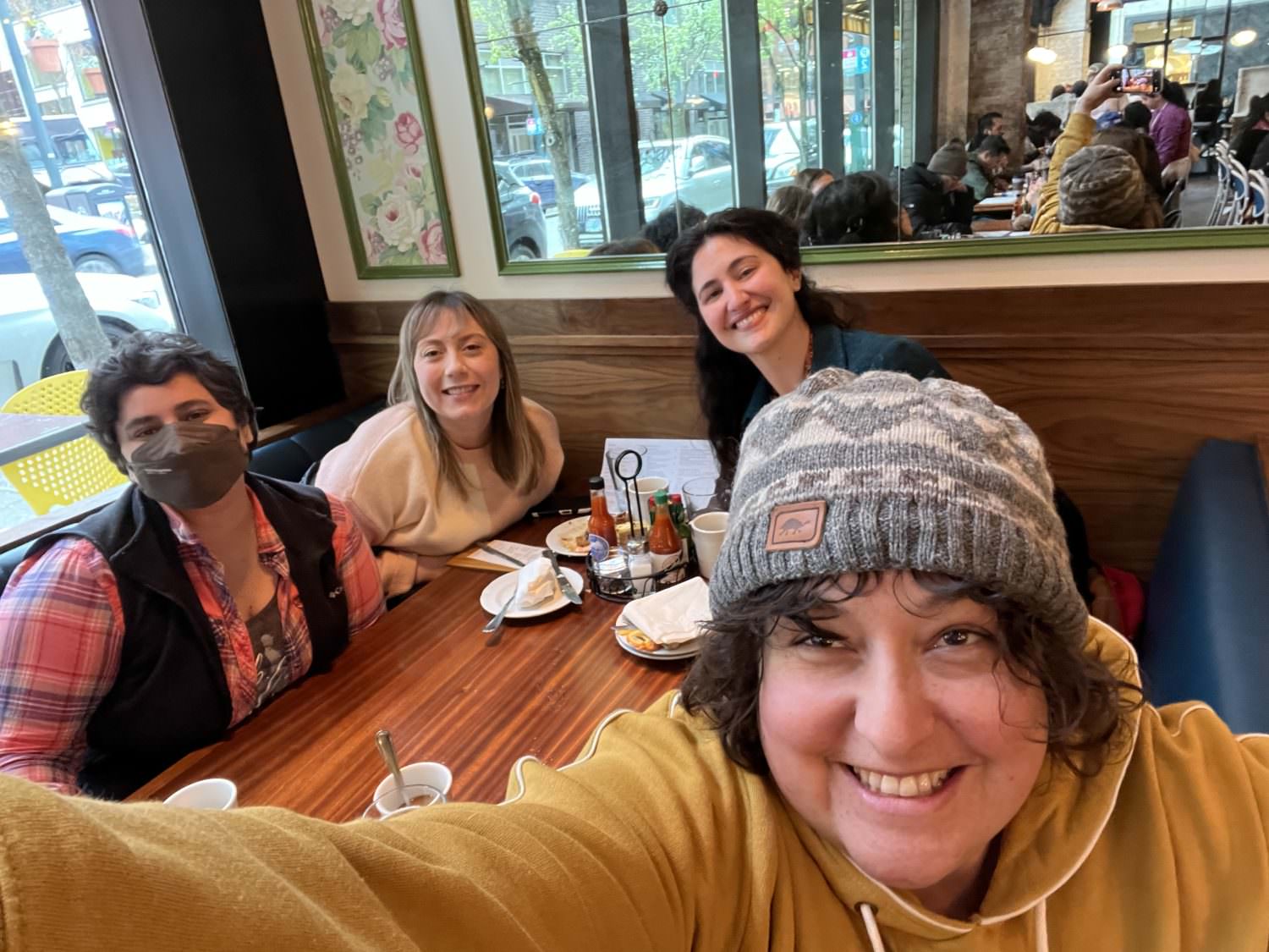 Image of four people smiling and having lunch at a restaurant.