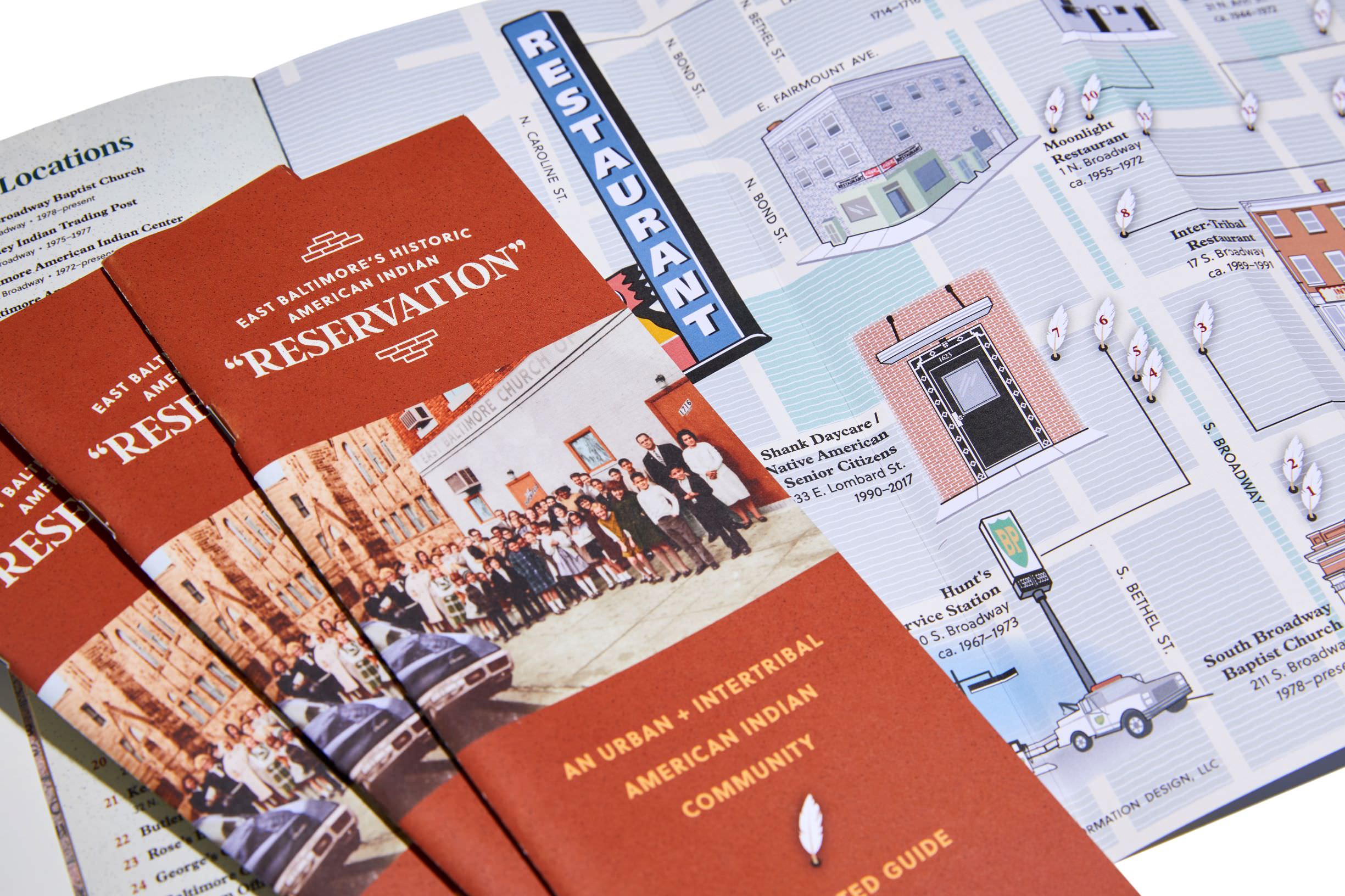 brick red brochures laid out in a fan pattern with an open brochure laid underneath