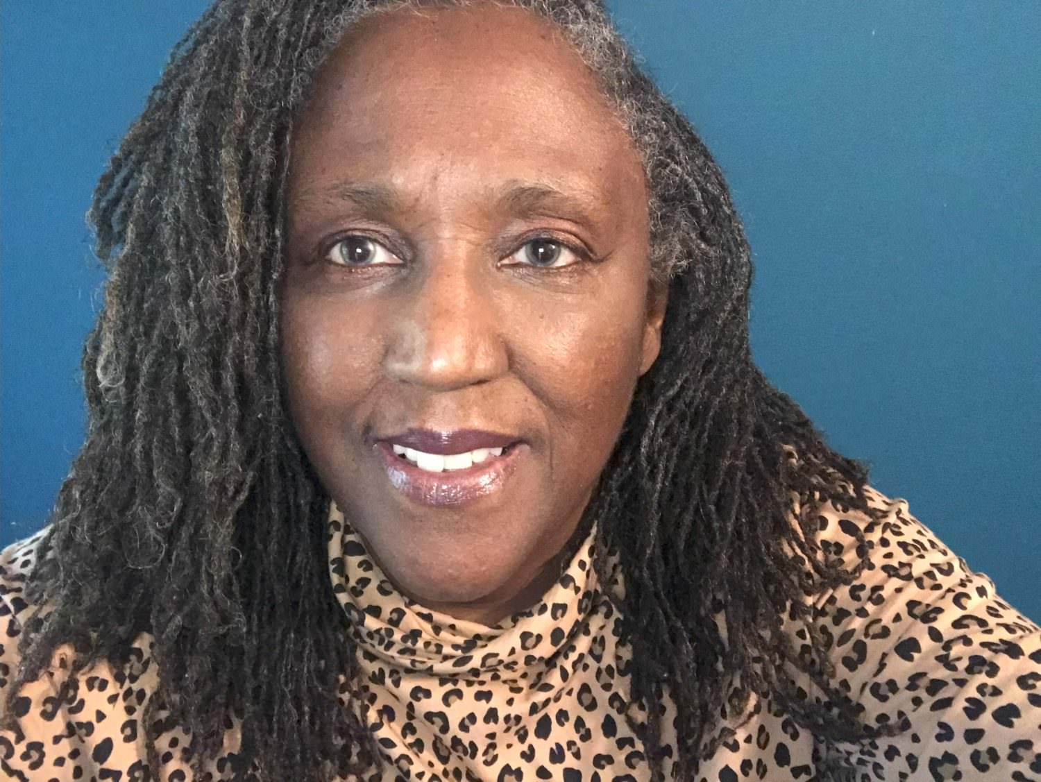 The photo is a close up, with robinson wearing an animal print turtuleneck.