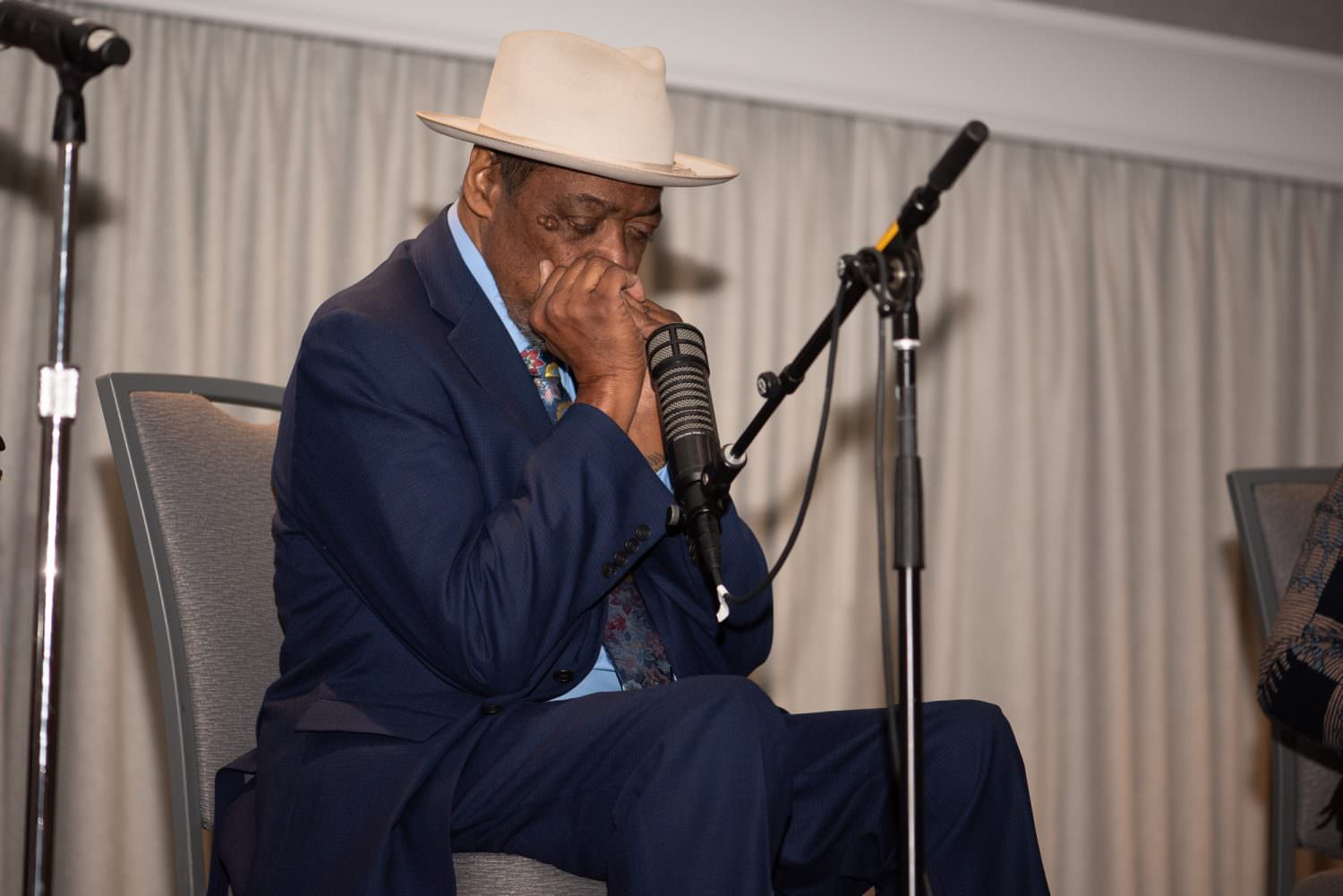 phil wiggins playing his harmonica into a microphone