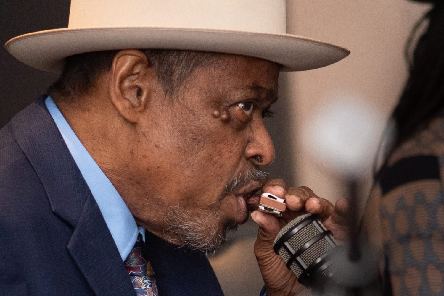 close-up of phil wiggins playing harmonica into a microphone