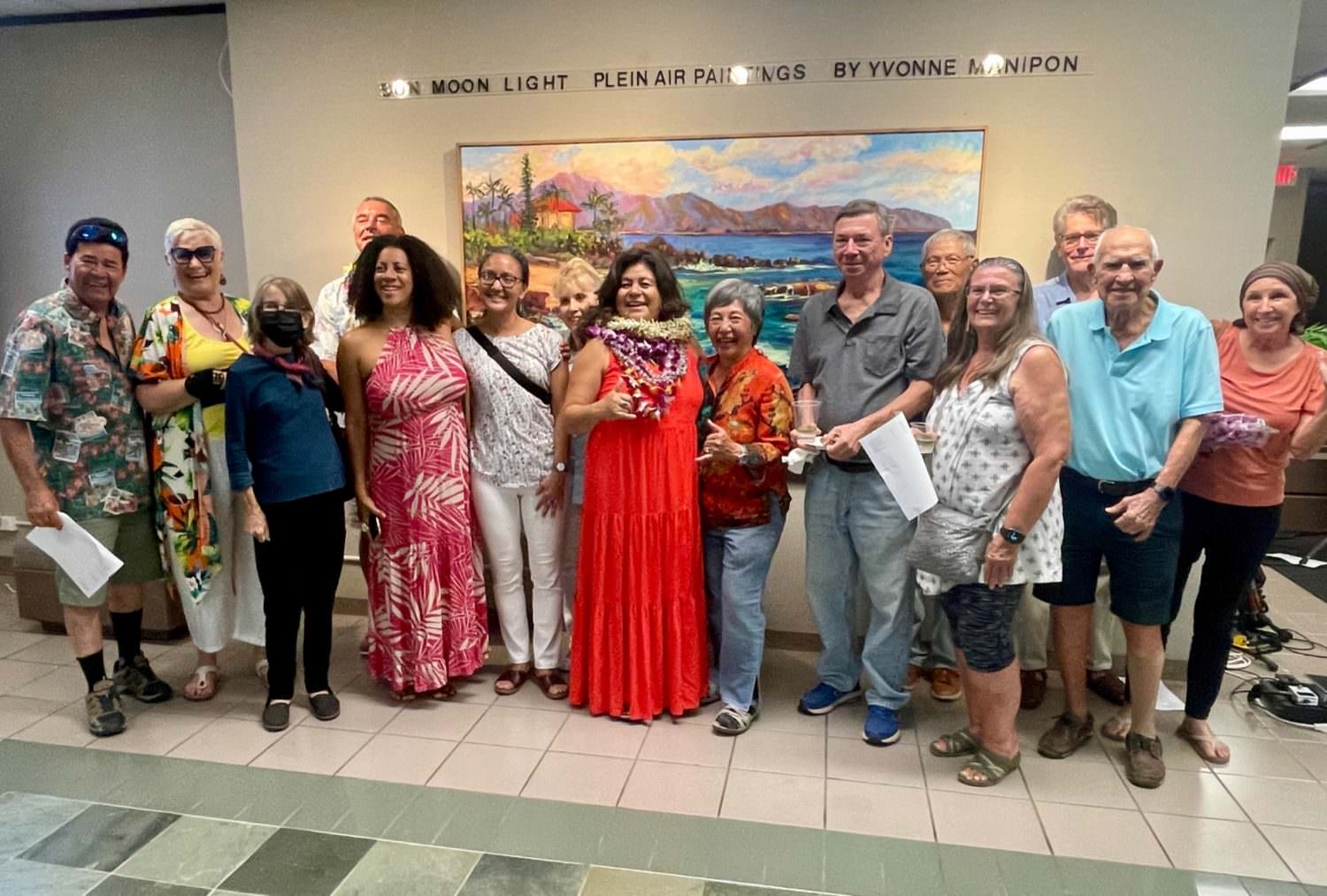 yvonne manipon with friends and family in front of her painting at an exhibit