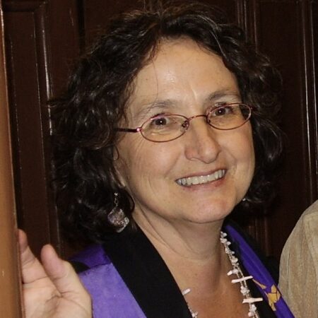 Smiling middle-aged woman with glasses and necklace